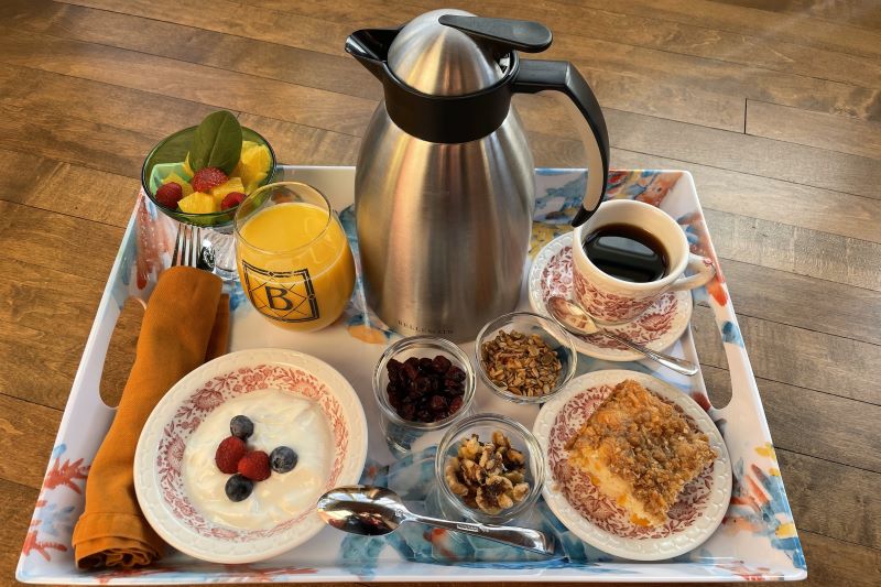 Continental breakfast of coffee orange juice fresh fruit yogurt berries granola and coffee cake